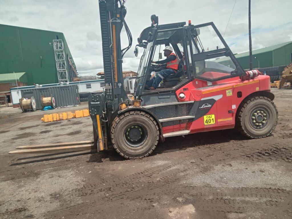 Facilitator with a learner on a forklift during training
